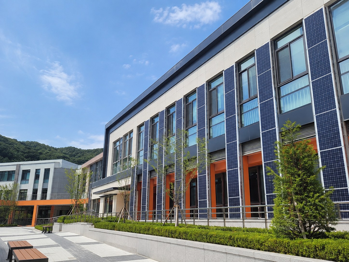 세련된 학교 건물 외벽에 설치된 경량 태양광 패널
